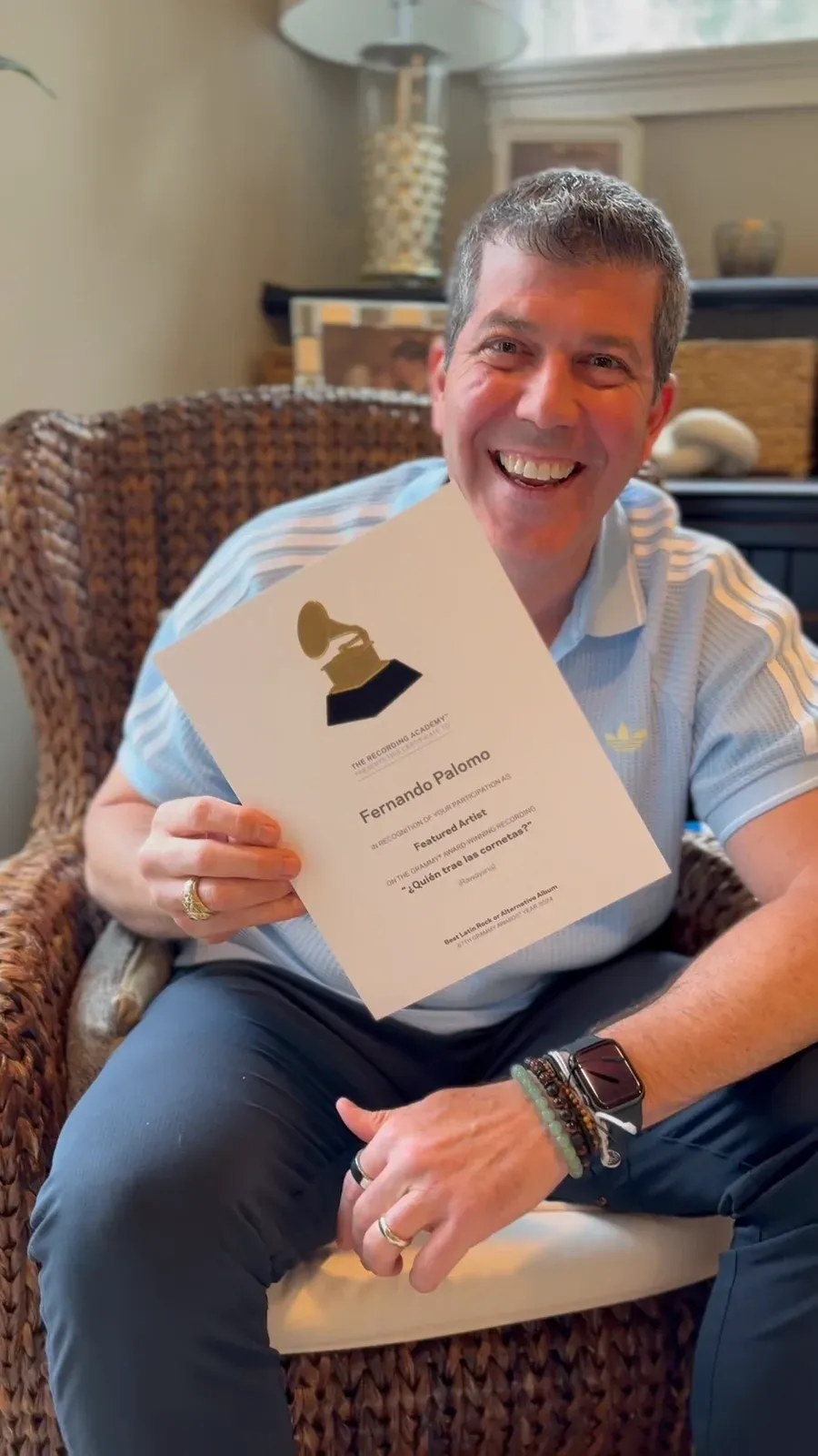 Fernando Palomo, sonriente en un sillón, sostiene el certificado del GRAMMY obtenido junto a Rawayana.