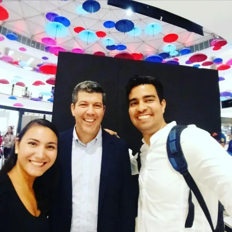 Tres personas en un evento en Panamá, en medio usando un traje Fernando Palomo