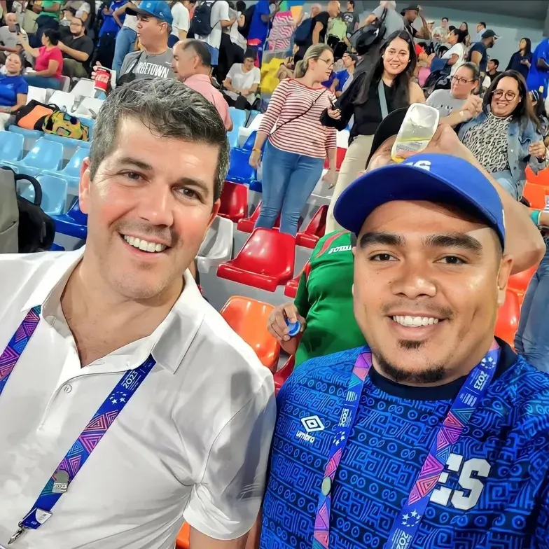 En un estadio, a la derecha una persona con la camiseta de la selección salvadoreña y a la izquierda Fernando Palomo