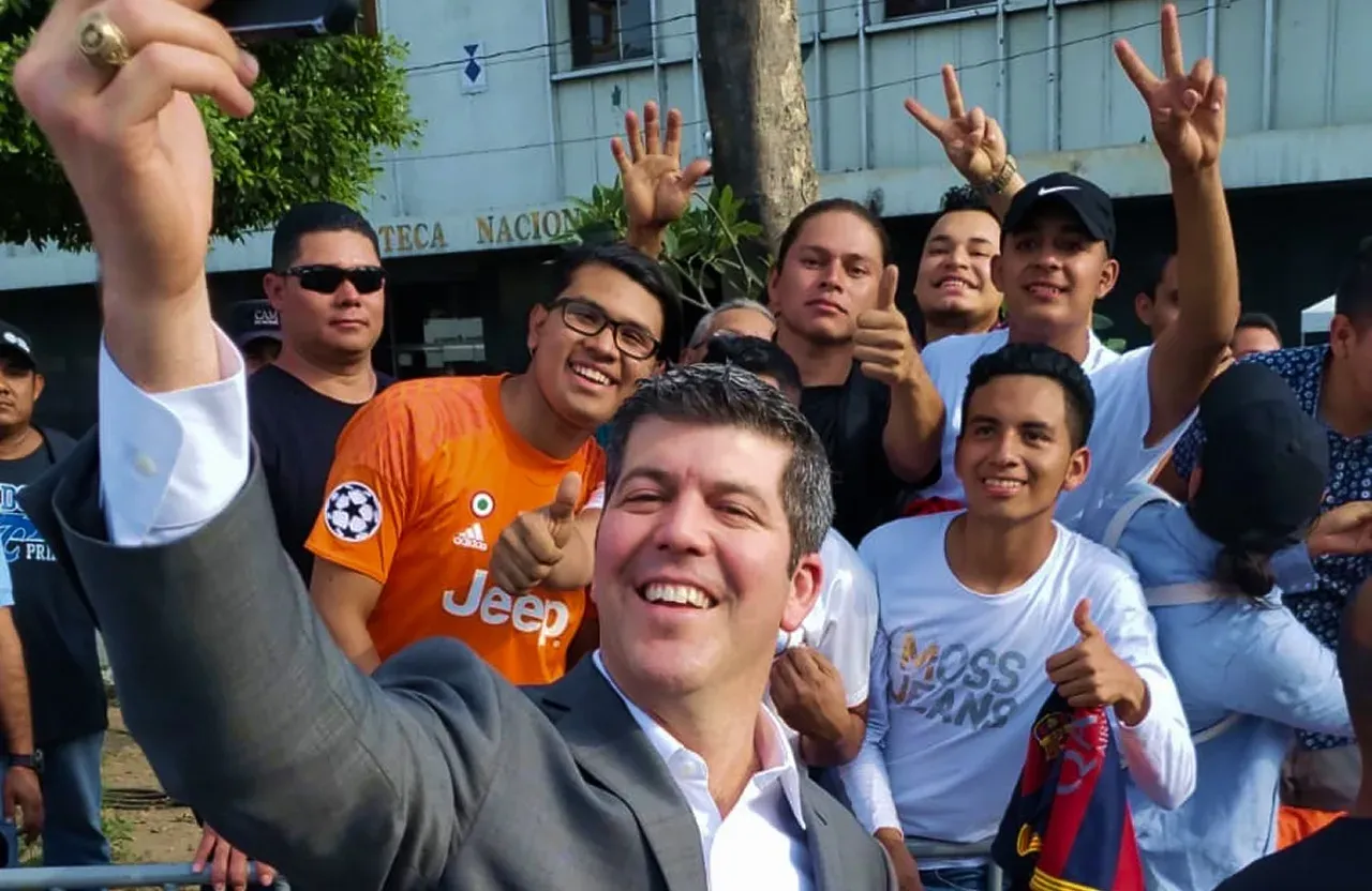Fernando Palomo se toma una selfie en la calle con un grupo de aficionados que sonríen, levantan el pulgar y hacen la señal de la victoria.
